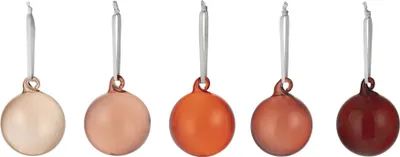 Five glass ornaments in varying shades of red and orange, hanging from white ribbons.