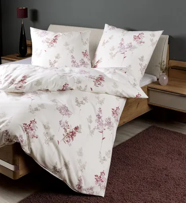 A neatly made bed with floral patterned bedding.