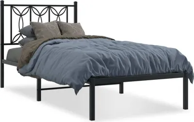 A black metal bed frame with a headboard, mattress, and bedding.