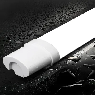 A close-up of the end of a white LED light fixture with water droplets on a black surface.