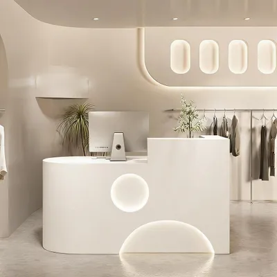 A modern retail store interior with a reception desk and clothing rack.