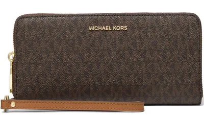 A brown Michael Kors wallet with a tan wrist strap is shown against a white background.