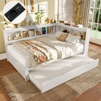A white wooden bed with a trundle bed pulled out, set up in a bedroom with shelves filled with decor and books.