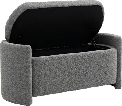 A gray upholstered storage bench with its lid open, revealing the black interior.