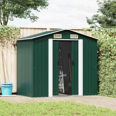 A green metal garden shed is shown outdoors on a paved area, with grass and foliage in the background.