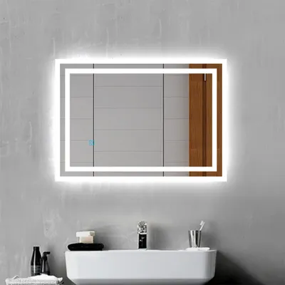 A modern bathroom vanity with a lit mirror above it.