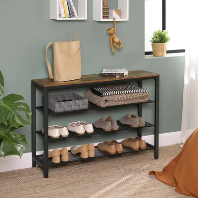 A shoe rack with shoes, bags, and blankets arranged on it, in a room setting.