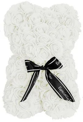 A white rose bear with a black ribbon tied around its neck.