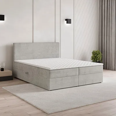 A modern bedroom setting with a light gray boxspring bed as the main focus.