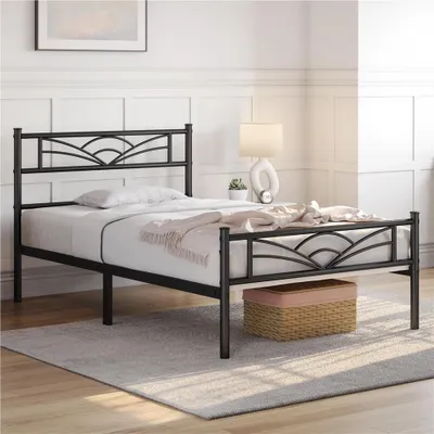 A black metal bed frame with a decorative headboard and footboard is shown in a bedroom setting.