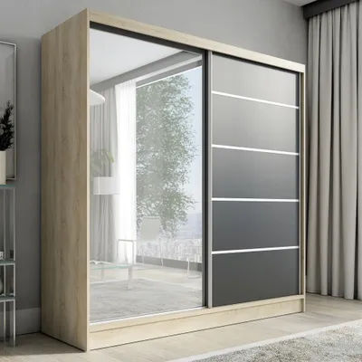 A modern sliding door wardrobe with a mirrored panel and a black and white segmented door is shown in a room.