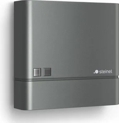 A dark gray electronic device mounted on a white wall.