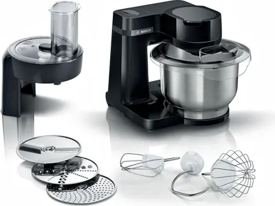 A black Bosch kitchen machine with a stainless steel bowl and various attachments, including a food processor and different beaters, is displayed on a white reflective surface.