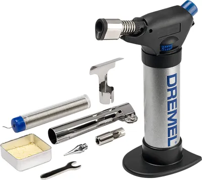 A Dremel VersaFlame butane torch and its accessories are laid out on a white background.