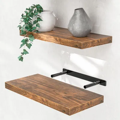 Two wooden shelves mounted on a white wall, one with decorative items and the other showing its mounting bracket.