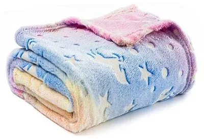 Zusammengefaltete mehrfarbige Decke mit pastellfarbenem Regenbogenverlauf und geprägten, im Dunkeln leuchtenden Einhörnern und Sternen