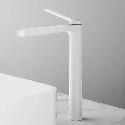 A white matte faucet is shown in a studio setting, with a white sink partially visible in the foreground.