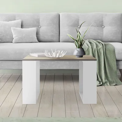 A modern living room scene with a light gray sofa, a coffee table, and a green throw blanket.