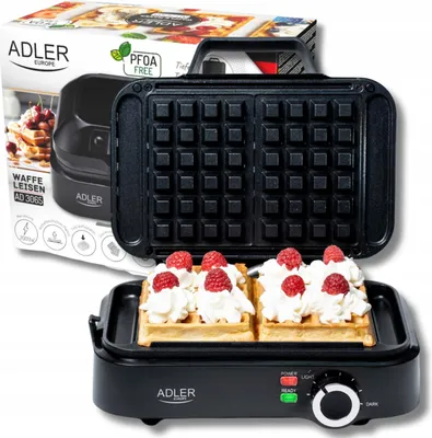 A waffle maker with two waffles topped with whipped cream and raspberries, next to its packaging.