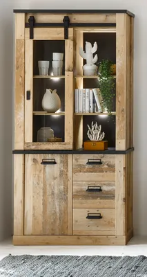 A wooden vitrine cabinet with glass doors and drawers, decorated with various items.