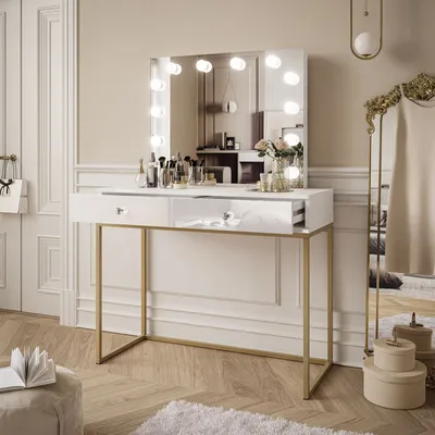 A modern vanity table with a lighted mirror, makeup, and decorative items in a well-lit room.