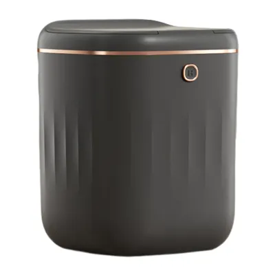 A dark gray automatic trash can with a copper trim and a small circular button on the front.