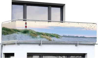 A balcony screen with a beach and lighthouse pattern is attached to the railing of a balcony.