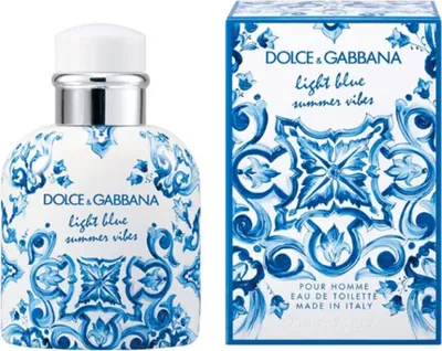 A bottle of Dolce & Gabbana Light Blue Summer Vibes Pour Homme Eau De Toilette and its packaging are displayed side-by-side against a white background.