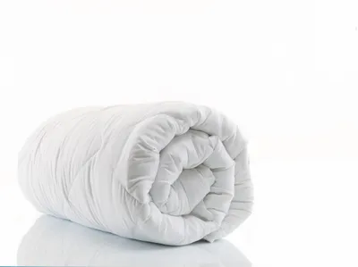 A white rolled-up duvet is displayed against a white background.