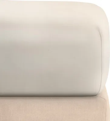 A close-up view of a beige fitted sheet on top of another beige fabric surface.