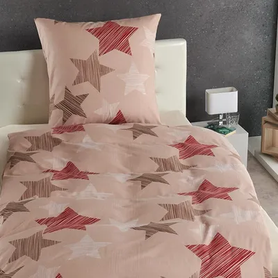 A bed with beige bedding featuring a star pattern.