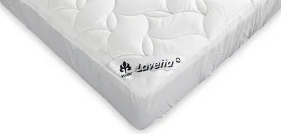 A close-up, angled view of a white mattress topper with a quilted pattern and a brand logo.