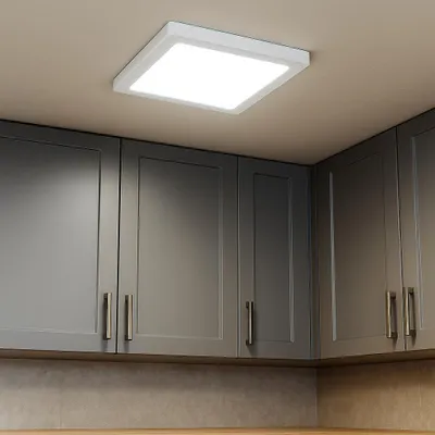 A square white LED ceiling light is mounted on a light-colored ceiling above dark gray kitchen cabinets.