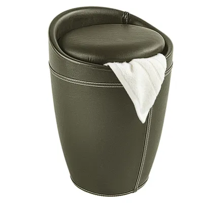 A brown leather-look laundry basket with a white towel draped over the edge.