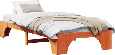A wooden bed frame with bedding on a white background.