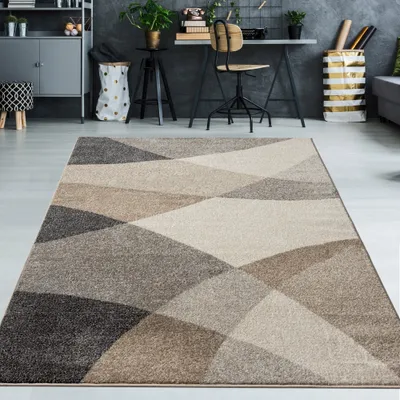 A modern living room or office space with a geometric rug in the foreground and a desk area in the background.