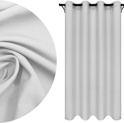 A close-up of white fabric texture and a white eyelet curtain hanging on a rod.