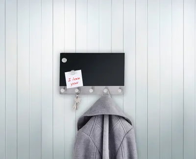 A black magnetic coat rack with hooks, a grey jacket hanging from it, and a note attached to the rack.