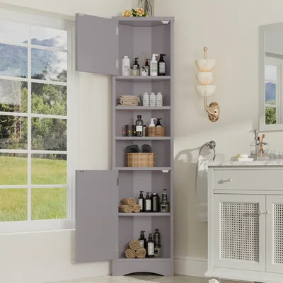 A gray corner cabinet with several shelves filled with toiletries and towels, placed next to a window with a view of greenery.