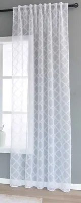 A white sheer curtain with a diamond pattern hangs in front of a window.