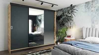 A bedroom with a large wardrobe with mirrored doors, a bed, and a tropical-themed wallpaper.