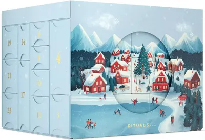 A light blue advent calendar with a winter village scene depicted on the front, featuring red houses, snow-covered mountains, and people ice skating.