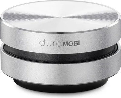 A close-up studio shot of a small, cylindrical, silver and black portable speaker.