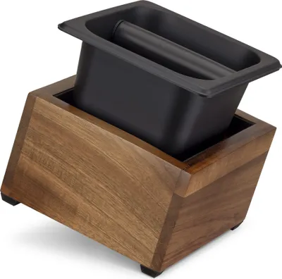 A knock box with a tamper sits on a wooden stand.