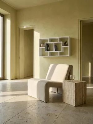 Geometrisches Wandregal aus weißem MDF im minimalistischen Wohnzimmer an einer handverputzten Wand über einem Leinen-Sessel_#sku_SAFWL5.167#