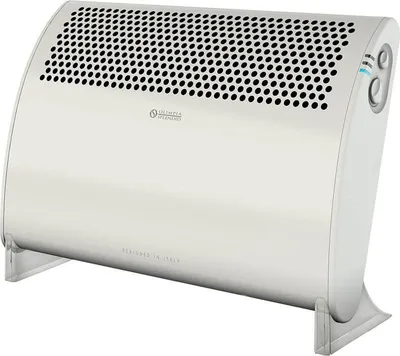 A white electric heater with a perforated top and a curved body, standing on two gray legs.
