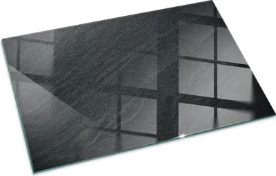 A rectangular glass plate with a textured, dark gray surface, reflecting a grid pattern.