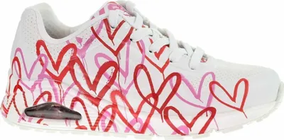 A side view of a white sneaker with a red and pink heart pattern.