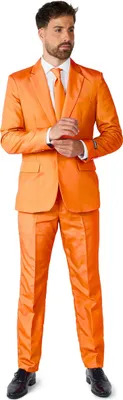 A man wearing an orange suit, white shirt, and orange tie, standing against a white background.