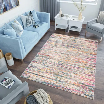 A living room scene with a blue sofa, a colorful rug, and accent furniture.